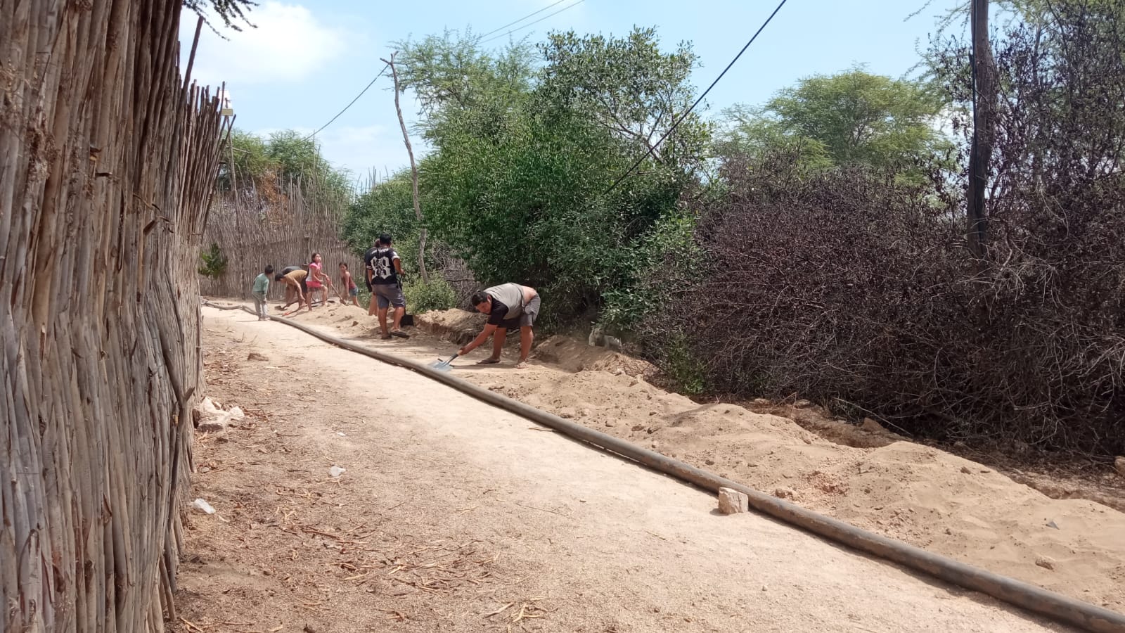 Familias de la comunidad colaborando en la apertura de zanjas para enterrar la tubería.